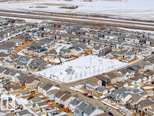 Overhead view of a residential neighbourhood featuring a large central park area with playground equipment, surrounded by properties with varying architectural styles - 17534 60A Street, Edmonton, AB - Outdoor With View