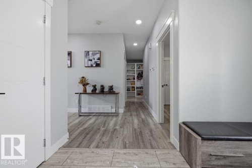 Hallway featuring light wood-style flooring, recessed lighting, and a white door with horizontal paneling - 17534 60A Street, Edmonton, AB - Indoor Photo Showing Other Room