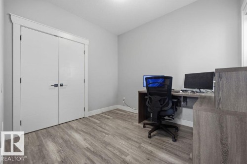 This room features hard surface flooring, light grey painted walls, and white bi-fold doors with modern hardware - 17534 60A Street, Edmonton, AB - Indoor Photo Showing Office