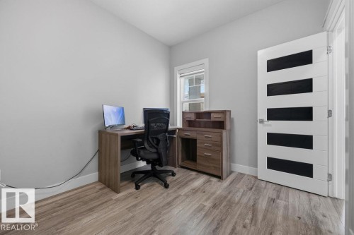 This versatile room features light-toned walls, wood-style flooring, and a window providing natural light - 17534 60A Street, Edmonton, AB - Indoor Photo Showing Office