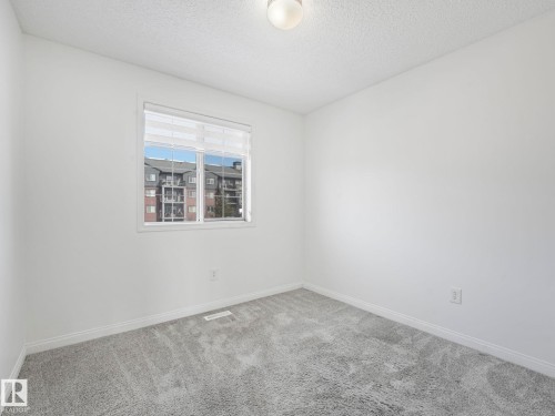 This room features light grey carpeting and a window with horizontal blinds - 675 Mcallister Loop, Edmonton, AB - Indoor Photo Showing Other Room