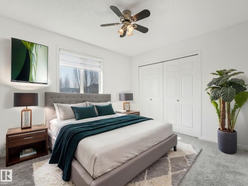 This bedroom features clean white walls, a window with roller blinds, and a ceiling fan with integrated lighting - 675 Mcallister Loop, Edmonton, AB - Indoor Photo Showing Bedroom