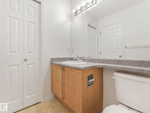 Bathroom featuring a vanity with a light wood finish, a white sink, and a large mirror with overhead lighting - 675 Mcallister Loop, Edmonton, AB - Indoor Photo Showing Bathroom