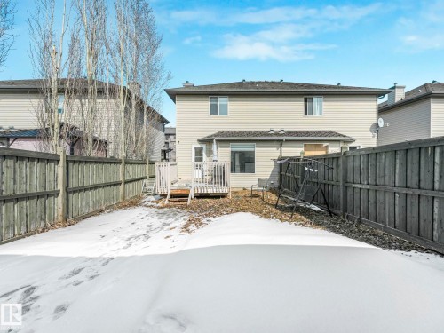This property features a backyard with a wooden fence and a deck with steps leading down to the yard - 675 Mcallister Loop, Edmonton, AB - Outdoor