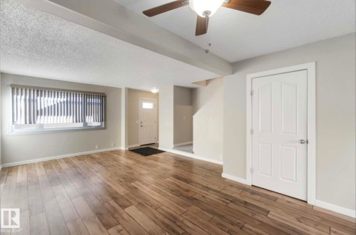 The living area features hardwood floors and a ceiling fan with integrated lighting - 8 14511 52 Street, Edmonton, AB - Indoor Photo Showing Other Room