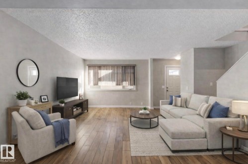 Living area featuring hardwood flooring, light-colored walls, and a window with blinds - 8 14511 52 Street, Edmonton, AB - Indoor Photo Showing Living Room