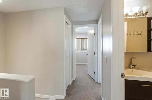 Hallway with light gray walls, carpeted flooring, and white trim - 8 14511 52 Street, Edmonton, AB - Indoor Photo Showing Other Room