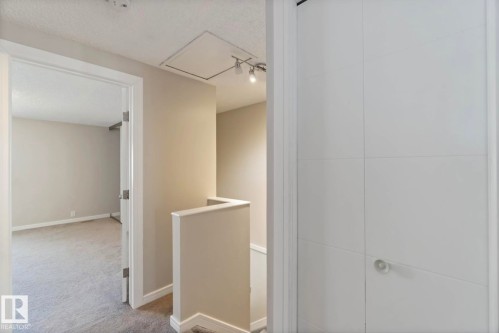 Hallway featuring light neutral wall paint, white trim, and a white interior door - 8 14511 52 Street, Edmonton, AB - Indoor Photo Showing Other Room