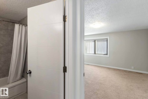 The property features a room with light-colored carpeted flooring, a window with blinds, and light-colored walls - 8 14511 52 Street, Edmonton, AB - Indoor