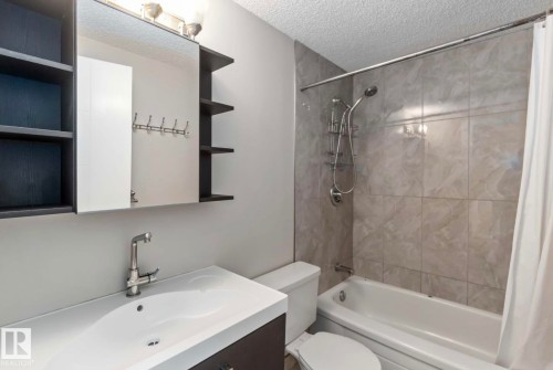 Bathroom with a contemporary vanity, medicine cabinet with open shelving, and a tiled shower-bathtub combination - 8 14511 52 Street, Edmonton, AB - Indoor Photo Showing Bathroom