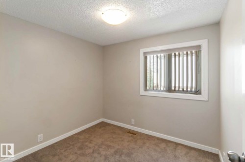 This room features neutral-toned walls, a window with vertical blinds, and carpeting - 8 14511 52 Street, Edmonton, AB - Indoor Photo Showing Other Room