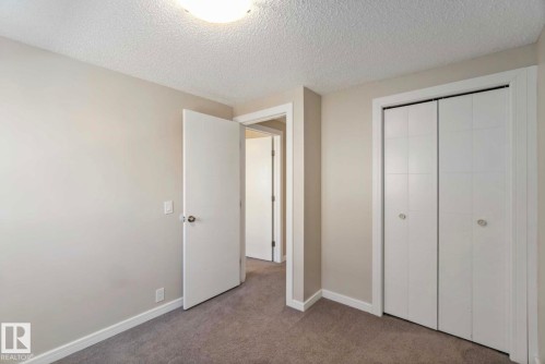 The room features light gray walls, white trim, and gray carpet flooring - 8 14511 52 Street, Edmonton, AB - Indoor