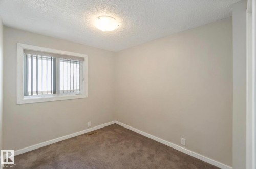 This room features neutral-toned walls, textured ceilings, and wall-to-wall carpeting - 8 14511 52 Street, Edmonton, AB - Indoor Photo Showing Other Room