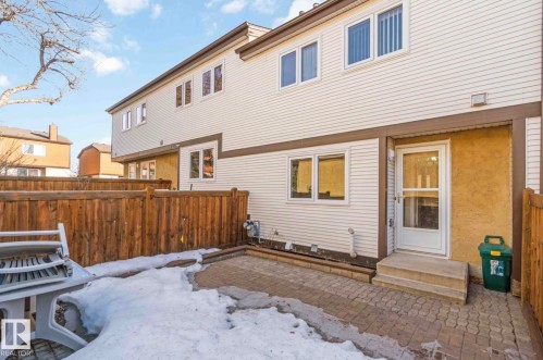 The property features a private patio area with paving stones, enclosed by a wooden fence - 8 14511 52 Street, Edmonton, AB - Outdoor With Exterior