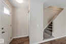 The property features a welcoming entryway with wood-style flooring and a white paneled door with an upper window - 8 14511 52 Street, Edmonton, AB  - Indoor Photo Showing Other Room 