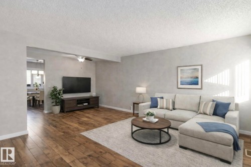 The spacious living area features hardwood flooring, light grey walls, and a ceiling fan - 8 14511 52 Street, Edmonton, AB - Indoor Photo Showing Living Room
