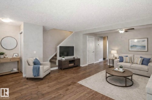 Spacious living area featuring wood flooring, a ceiling fan, and a neutral color palette - 8 14511 52 Street, Edmonton, AB - Indoor Photo Showing Living Room