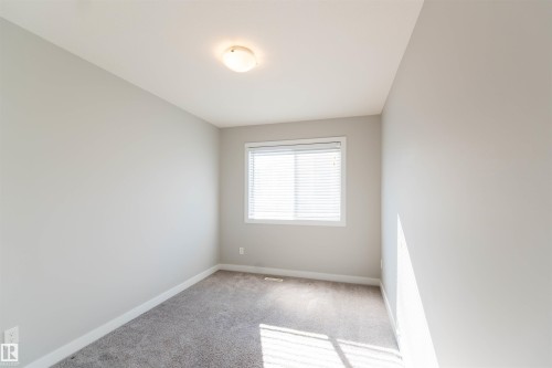 This space features neutral-toned walls, a window with blinds, and carpeting - 1793 Keene Crescent, Edmonton, AB - Indoor Photo Showing Other Room