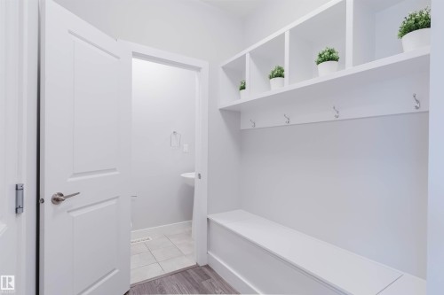 This mudroom features built-in white shelving with integrated coat hooks and a bench - 1793 Keene Crescent, Edmonton, AB - Indoor