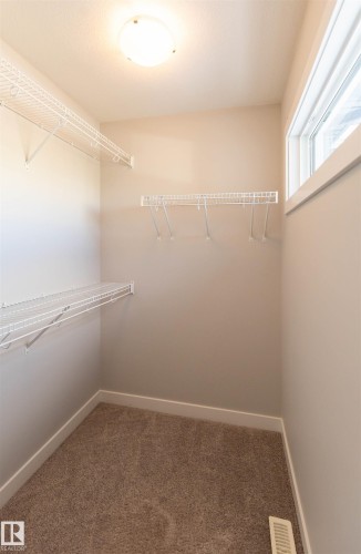 This closet features neutral toned walls, brown carpet flooring, and white wire shelving - 1793 Keene Crescent, Edmonton, AB - Indoor With Storage