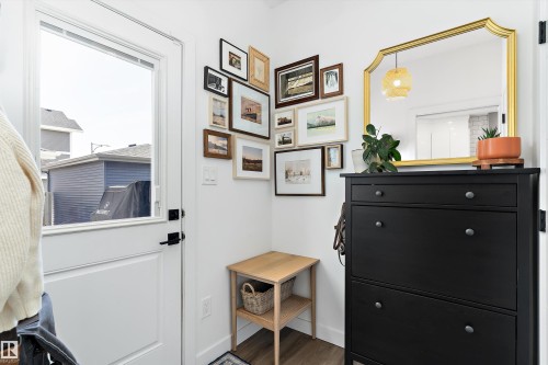 The entryway features a white door with a window, white walls, and wood flooring - 1305 Enright Landing, Edmonton, AB - Indoor