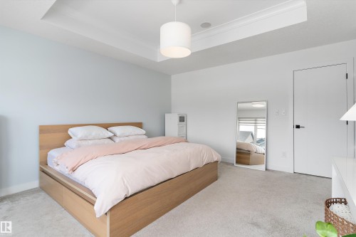 This room features light-colored walls and a tray ceiling with recessed lighting - 1305 Enright Landing, Edmonton, AB - Indoor Photo Showing Bedroom