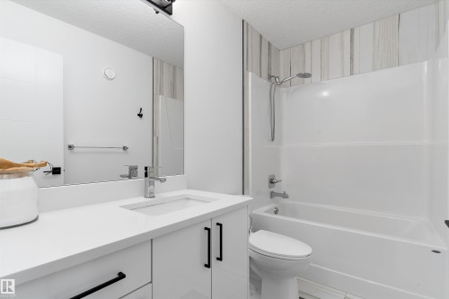 Bathroom featuring a white vanity with a rectangular sink, chrome faucet, and black hardware - 1305 Enright Landing, Edmonton, AB - Indoor Photo Showing Bathroom