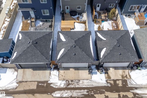 This property features a dark shingle roof and an attached garage with a concrete driveway - 1305 Enright Landing, Edmonton, AB - Outdoor