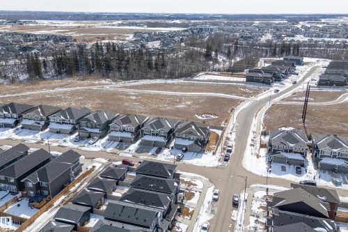 Aerial view showcasing a residential area with varied housing types, paved roads, and open undeveloped land - 1305 Enright Landing, Edmonton, AB - Outdoor With View