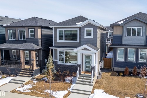 The property features a two-story exterior with a combination of horizontal siding, shake siding, and stone accents - 1305 Enright Landing, Edmonton, AB - Outdoor With Facade
