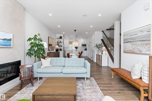 The property features an open-concept living space with hardwood flooring, recessed lighting, and a modern fireplace - 1305 Enright Landing, Edmonton, AB - Indoor Photo Showing Living Room