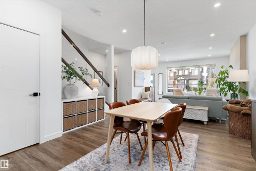 The property features an open-concept living area with hardwood flooring, recessed lighting, and a modern light fixture above the dining space - 1305 Enright Landing, Edmonton, AB - Indoor