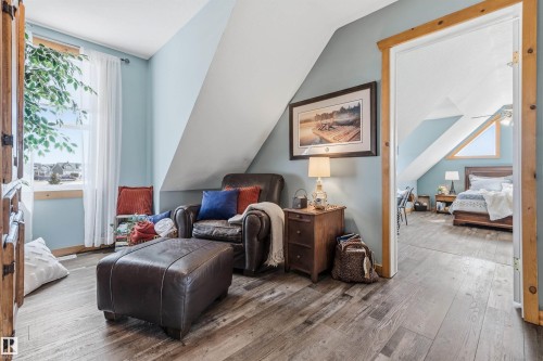 This inviting space features light blue walls, wood-look flooring, and a window with white curtains - 17 Sunset Harbour, Rural Wetaskiwin County, AB - Indoor