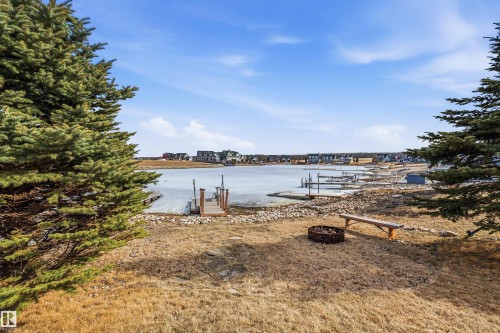 The property offers a waterfront view with a private wooden dock leading to the water - 17 Sunset Harbour, Rural Wetaskiwin County, AB - Outdoor With Body Of Water With View