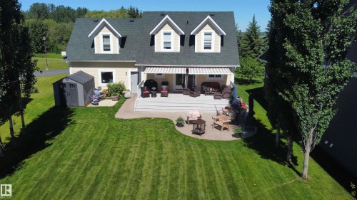 Expansive rear yard with a well-maintained lawn and mature trees - 17 Sunset Harbour, Rural Wetaskiwin County, AB 