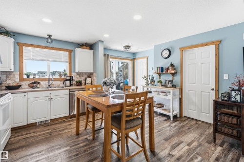 The kitchen features white cabinetry, a light-colored tile backsplash, and a window above the sink - 17 Sunset Harbour, Rural Wetaskiwin County, AB - Indoor