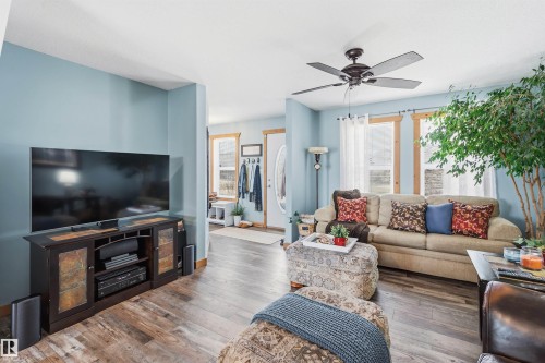 Living area featuring light blue walls, wood-look flooring, and a ceiling fan - 17 Sunset Harbour, Rural Wetaskiwin County, AB - Indoor Photo Showing Living Room