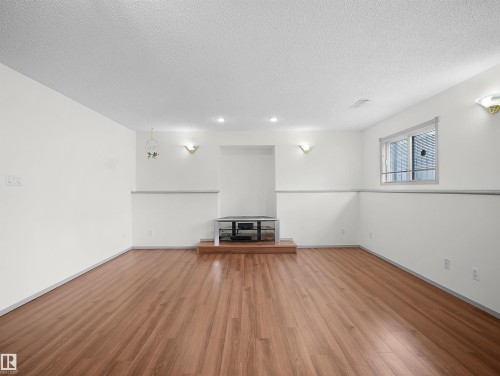 This versatile room features hardwood flooring, white walls, and recessed lighting - 14523 32 Street, Edmonton, AB - Indoor Photo Showing Other Room
