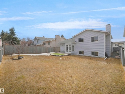 The property features a spacious backyard with a lawn, a fenced perimeter, and a light-colored siding exterior - 14523 32 Street, Edmonton, AB - Outdoor