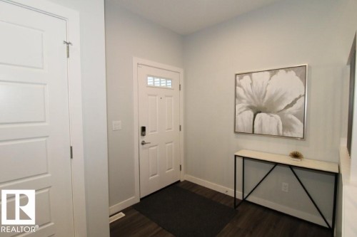 The property features a white paneled door with glass inserts, dark flooring, and light-colored walls - 22140 81 Avenue, Edmonton, AB 