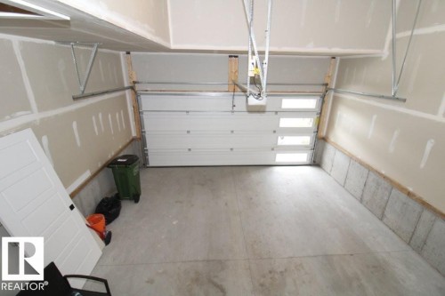 The garage features a concrete floor and a white sectional garage door with frosted window panels - 22140 81 Avenue, Edmonton, AB 
