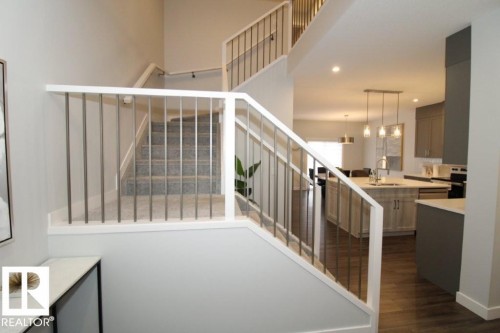The property features a staircase with carpeted treads and modern white railings with metal balusters - 22140 81 Avenue, Edmonton, AB 