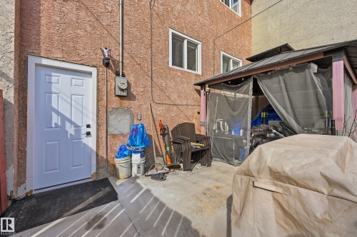 The property features an exterior with a textured finish and white-framed windows - 9031 133 Avenue, Edmonton, AB - Outdoor With Exterior