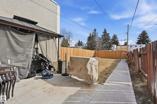 The property includes a concrete patio area, a concrete pathway, a wooden fence, and a gazebo with mesh screens - 9031 133 Avenue, Edmonton, AB - Outdoor
