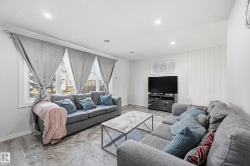 The living area features recessed lighting, durable flooring, and ample natural light from the windows - 9031 133 Avenue, Edmonton, AB - Indoor Photo Showing Living Room