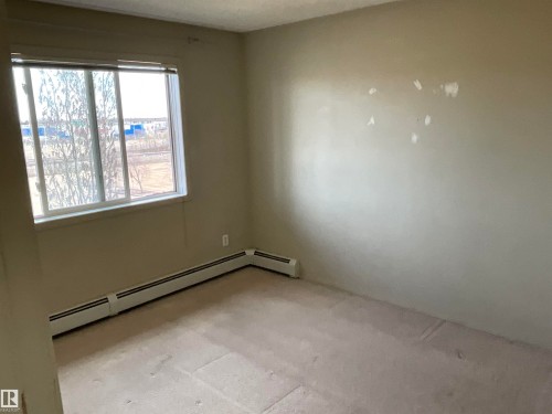 Carpeted room featuring a single window and baseboard heating - 408 309 Clareview Station Drive Nw, Edmonton, AB - Indoor Photo Showing Other Room