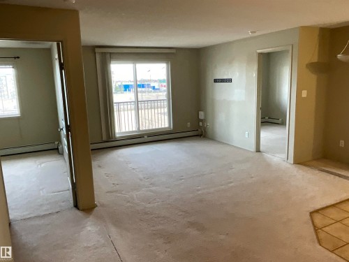 Expansive living area featuring light-toned carpeting and neutral wall finishes - 408 309 Clareview Station Drive Nw, Edmonton, AB - Indoor Photo Showing Other Room