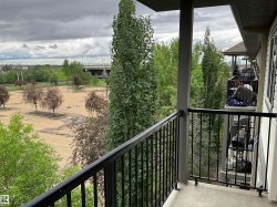 Private balcony with a concrete floor, black metal railings, and a grey structural column - 