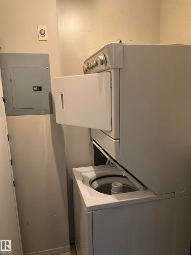 Dedicated laundry space featuring a white stacked washer and dryer unit - 408 309 Clareview Station Drive Nw, Edmonton, AB - Indoor Photo Showing Laundry Room