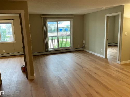 Spacious interior featuring light wood-finish flooring, neutral wall tones, and white trim - 408 309 Clareview Station Drive Nw, Edmonton, AB 